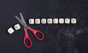 Un paio di forbici taglia il prefisso "in" dalla parola "inequality"
